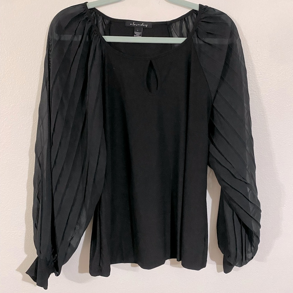 Black blouse with sheer flowy sleeves and peep hole in chest.